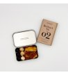 Biossom Snack Tin No. 02 – open tin with fruit, chocolate and nuts next to the product packaging